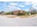 Tan house with red tile roof and a corner lot at 7702 Northaven Pl, Trinity, FL 34655