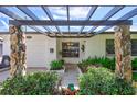 Elegant front entry with pergola, stone pillars, and lush landscaping at 8532 Kumquat Ave, Seminole, FL 33777