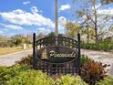 Community entrance sign for Pinewinds, featuring a logo and a wrought-iron frame at 10 Morning Dove Pl, Oldsmar, FL 34677