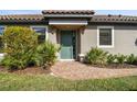 Inviting front entrance with a teal door, brick pathway, and lush landscaping at 11125 Callisia Dr, Odessa, FL 33556