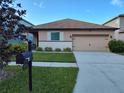 One-story house with a two-car garage and well-manicured lawn at 13504 Red Ear Ct, Riverview, FL 33569