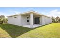 Covered patio with sliding glass doors, and grassy backyard at 19474 Strathcona Ave, Port Charlotte, FL 33954