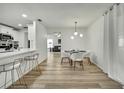 Bright dining room featuring modern light fixture and seating for six, with kitchen and living room views at 2603 Royal Ridge Dr, Spring Hill, FL 34606