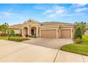 Tan house with three car garage and lush landscaping at 4041 Woodland Retreat Blvd, New Port Richey, FL 34655