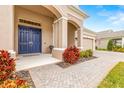 Inviting front entrance with a navy blue double door and a brick walkway at 4041 Woodland Retreat Blvd, New Port Richey, FL 34655