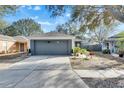 One-story house with gray garage door and nicely landscaped yard at 410 Pine Pointe Ct, Seffner, FL 33584