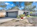 One-story house with gray garage door, landscaping, and a walkway at 410 Pine Pointe Ct, Seffner, FL 33584