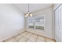Cozy dining area featuring a window, tile floor and a stylish chandelier at 4317 Knollcrest Ct, Spring Hill, FL 34609
