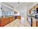Well-lit kitchen with ample counter space, tile floors, wooden cabinets, and stainless steel appliances at 4317 Knollcrest Ct, Spring Hill, FL 34609