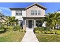 Two-story house with gray and beige siding, a stone base, and a walkway at 4909 4Th N Ave, St Petersburg, FL 33710