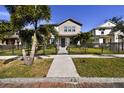 Two-story house with a metal fence, palm trees, and brick walkway at 4909 4Th N Ave, St Petersburg, FL 33710