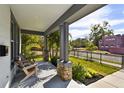 Porch with stone pillars, two wooden chairs, and a view of the street at 4909 4Th N Ave, St Petersburg, FL 33710