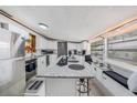 Modern kitchen featuring white cabinets, granite island, and stainless steel appliances at 6145 55Th N Ave, St Petersburg, FL 33709