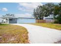 Front view of a light blue house with a long driveway at 10507 118Th Ter, Largo, FL 33773