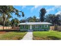 Newly renovated green house with metal roof and walkway at 1202 S Walker St, Plant City, FL 33563
