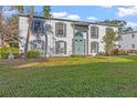 Two-story white brick building with green door, landscaping, and grassy yard at 1330 Snell Isle Ne Blvd # 4, St Petersburg, FL 33704