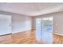 Living room with wood-look floors and sliding doors leading to a balcony and lake view at 13760 Orange Sunset Dr # 201, Tampa, FL 33618