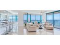 Bright living room featuring expansive windows with ocean views and comfortable seating with bar in the foreground at 1520 Gulf Blvd # 1602, Clearwater Beach, FL 33767