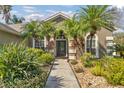 Welcoming entryway with lush landscaping and a paved walkway at 27544 Kirkwood Cir, Wesley Chapel, FL 33544