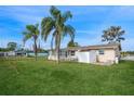Large backyard with a shed, lush grass, and palm trees at 3034 Domino Dr, Holiday, FL 34691