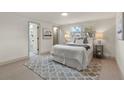 Bright bedroom featuring a comfortable queen-size bed, stylish rug, and an ensuite bathroom for added convenience at 3551 Jackson Dr, Holiday, FL 34691