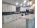 Updated kitchen boasting white cabinets, stylish backsplash, and a large island at 5198 40Th S St, St Petersburg, FL 33711