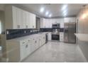 Modern kitchen with white cabinets, quartz countertops, and stainless steel appliances at 5198 40Th S St, St Petersburg, FL 33711