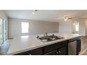 Kitchen island with double sink, white countertop, and dark brown cabinetry at 849 Haleybury St, Port Charlotte, FL 33948