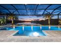 Relaxing pool with a covered patio and lake view at 8621 Ivy Stark Blvd, Wesley Chapel, FL 33545