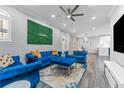 Bright and airy living room with blue velvet sofas and a large TV at 111 S Melville Ave # 4, Tampa, FL 33606