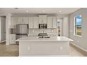 Modern kitchen with white cabinets, quartz countertops, and stainless steel appliances at 11482 Boundless Ter, Venice, FL 34293