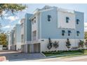 Modern three-story townhouses with light blue siding and attached garages at 1413 Bayshore Blvd # 9, Dunedin, FL 34698