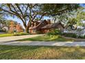 House exterior showcasing wood siding and mature tree at 1455 Briarwood Ct, Safety Harbor, FL 34695