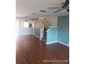 Living room with hardwood floors, stairs, and teal walls at 2566 Sea Wind Way, Clearwater, FL 33763