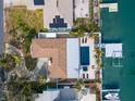 A serene aerial view featuring a private pool, dock, and lush landscaping at 280 N Julia Cir, St Pete Beach, FL 33706