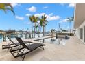 Inviting waterfront pool area with lounge chairs and lush palms, perfect for relaxation by the water at 280 N Julia Cir, St Pete Beach, FL 33706
