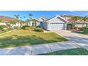 Single story home with a gray exterior, palm trees and well-kept lawn at 3320 Stonebridge Trl, Valrico, FL 33596