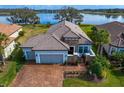 Beautiful single-Gathering home with a brick driveway, well manicured yard, and a stunning lake view at 3404 Forsythia Dr, Odessa, FL 33556