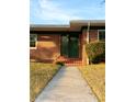 Green front door with glass panel and brick steps at 36847 Jefferson Ave, Dade City, FL 33523