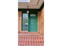 Green front door with glass sidelights and brick steps at 36847 Jefferson Ave, Dade City, FL 33523