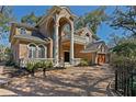 Luxury home featuring a brick facade, arched entry, upper balcony, and manicured landscaping at 4407 W Dale Ave, Tampa, FL 33609