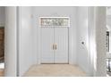 Elegant foyer featuring double doors with stained glass transom and neutral tiled floors at 4407 W Dale Ave, Tampa, FL 33609