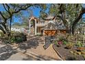 Charming brick home with wrought iron gate, mature trees, and meticulously maintained landscaping at 4407 W Dale Ave, Tampa, FL 33609