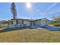 Updated light green house with a paved driveway and landscaped lawn at 6025 Florida S Cir, Apollo Beach, FL 33572