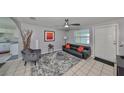 Living room with gray walls, leather couch, and ceiling fan at 6025 Florida S Cir, Apollo Beach, FL 33572