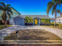 Gray house with yellow door and paver driveway at 743 Chesapeake Dr, Tarpon Springs, FL 34689