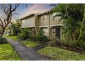 Tan two-story townhome with a landscaped front yard at 7606 Woodbridge Blvd, Tampa, FL 33615