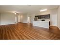 Open floor plan showcasing kitchen and living areas with wood flooring at 7849 Grafton Rd, North Port, FL 34291