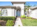 Inviting front entrance with a teal door and walkway, surrounded by manicured landscaping at 10524 Greencrest Dr, Tampa, FL 33626
