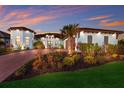 Beautifully landscaped home with a brick driveway, mature palm trees, and elegant exterior lighting at 1902 4Th E St, Palmetto, FL 34221